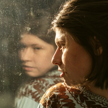 junge Frau schaut aus dem Fenster